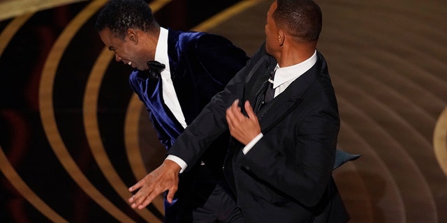 Will Smith colpisce Chris Rock prima che il comico presenti il ​​premio per il miglior documentario agli Academy Awards il 27 marzo 2022 a Los Angeles.