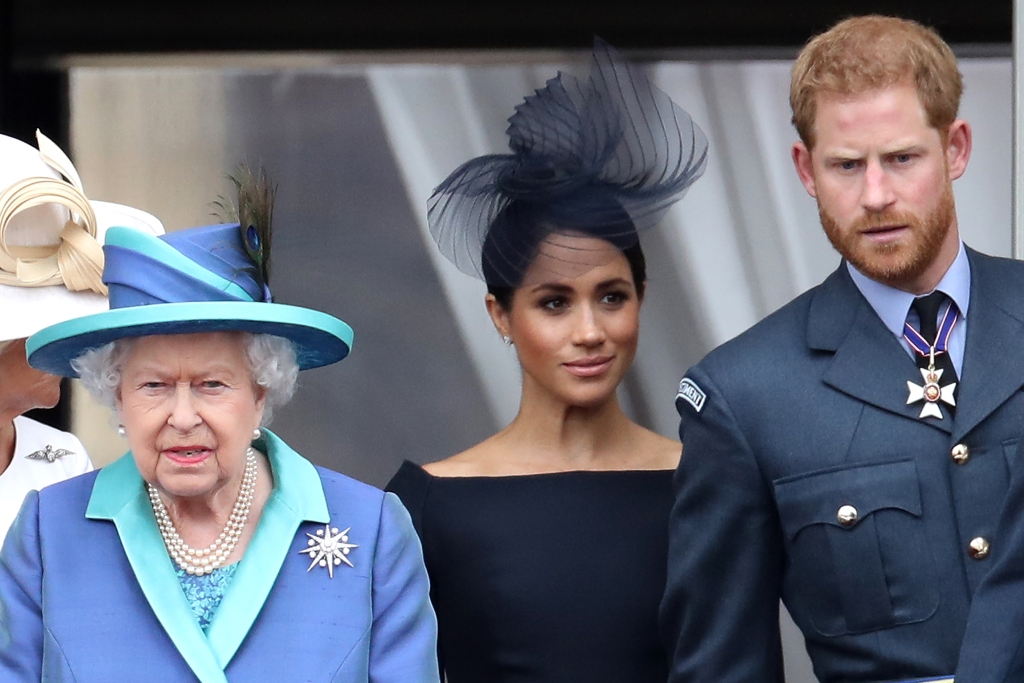 La regina Elisabetta II, il principe Harry, duca di Sussex e Meghan, duchessa di Sussex sul balcone di Buckingham Palace mentre la famiglia reale partecipa agli eventi per celebrare il centenario della RAF il 10 luglio 2018 a Londra, Inghilterra. 