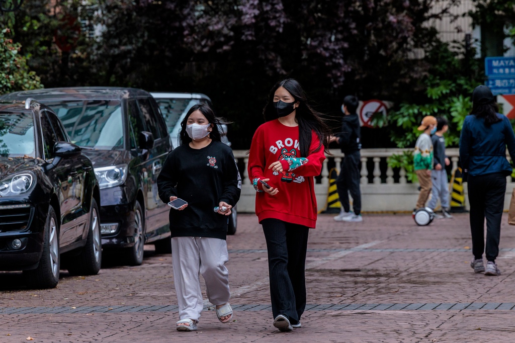 La gente cammina attraverso una comunità residenziale bloccata a Shanghai, in Cina, il 23 aprile 2022.