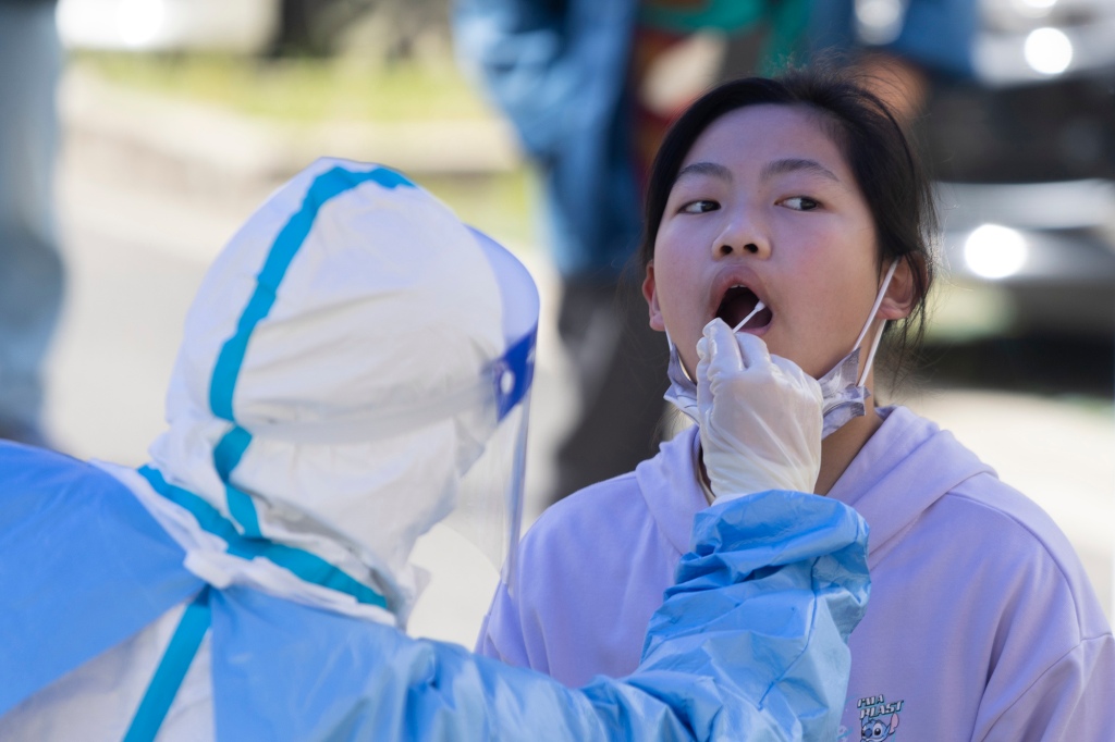 A Shanghai, in Cina, il 22 aprile 2022 una ragazza viene sottoposta a tampone in bocca per un test COVID-19.