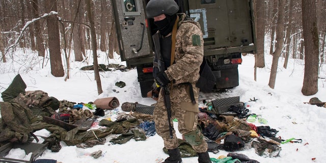 Un volontario delle forze di difesa regionali ucraine ispeziona un veicolo militare distrutto alla periferia di Kharkiv, la seconda città più grande dell'Ucraina, lunedì 7 marzo 2022.