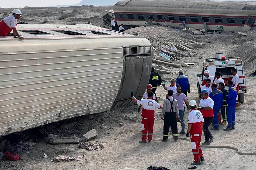 I soccorritori della Mezzaluna Rossa Iraniana lavorano sul luogo del deragliamento.