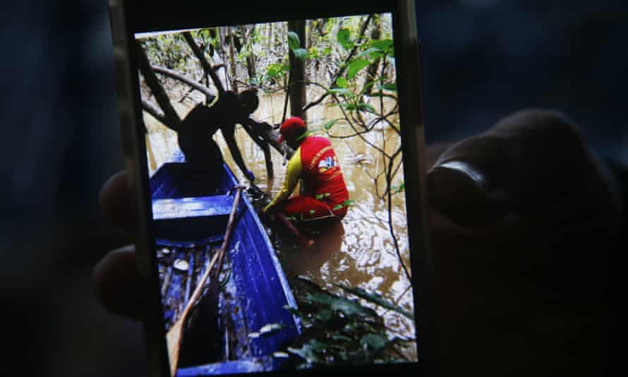 Un vigile del fuoco tiene in mano un telefono con una foto che mostra il momento in cui è stato trovato uno zaino durante la ricerca dell'esperto aborigeno Bruno Pereira e del giornalista britannico Dom Phillips