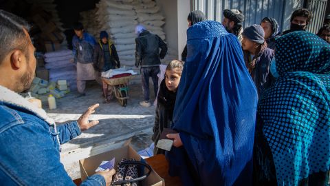 Una donna afgana riceve la razione mensile di generi alimentari della sua famiglia da un punto di distribuzione del Programma alimentare mondiale nel distretto di Jai Rais, a ovest di Kabul.