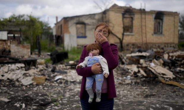 Nella Zelenska tiene una bambola appartenente a sua nipote davanti alla sua casa distrutta a Potashnya, fuori Kiev, in Ucraina, a maggio.