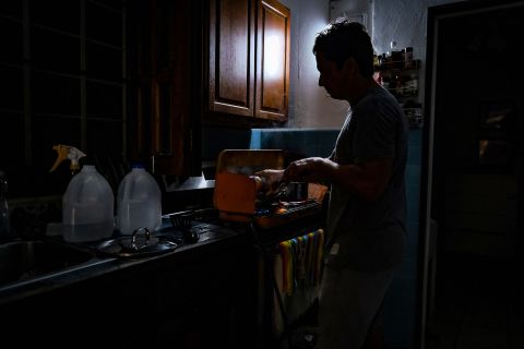 Lunedì una persona cucina al buio dopo aver perso il potere a San Juan, Porto Rico.