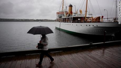 Un pedone si protegge con un ombrello mentre cammina lungo il lungomare di Halifax sotto la pioggia prima che l'uragano Fiona atterri ad Halifax, venerdì 23 settembre 2022.