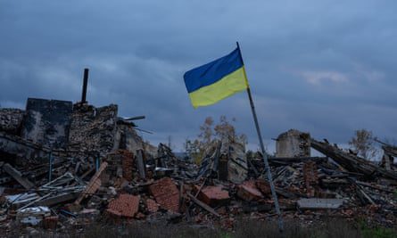 Una bandiera ucraina sventola sulle rovine degli edifici distrutti durante i combattimenti tra le forze di occupazione ucraine e russe a Kamyanka, nella regione di Kharkiv.