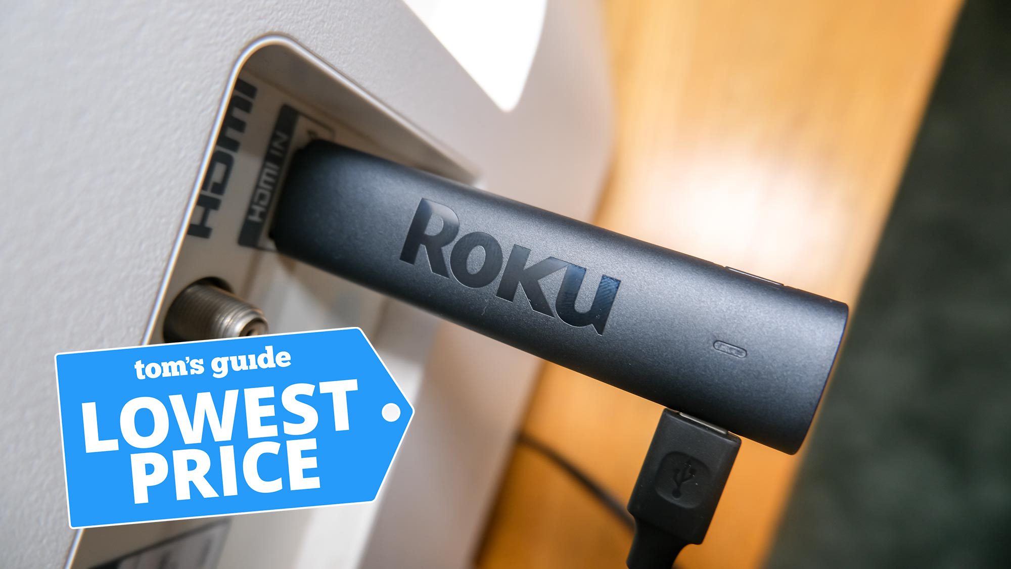 Roku Streaming Stick 4K è collegato a una porta HDMI con la grafica del prezzo più basso di Tom's Guide in alto