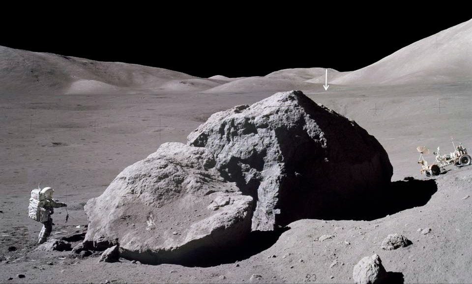 Il tempo di superficie dell'Apollo 17, il programma più longevo sulla Luna, era di tre giorni, due ore e cinquantanove minuti.  L'immagine mostra Jack Schmidt della navicella spaziale Apollo 17 che trasporta uno scorpione verso il modulo lunare dopo aver osservato e campionato il lato orientale di un enorme masso.  La freccia verticale in lontananza indica il Lunar Module Challenger, situato a circa 2 miglia (3,1 km) di distanza.