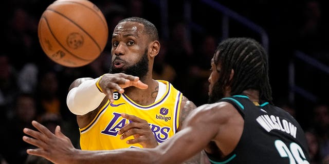 Los Angeles Lakers avanti LeBron James, a sinistra, passa la palla mentre Portland Trail Blazers avanti Justice Winslow difende durante la prima metà di una partita di basket NBA mercoledì 30 novembre 2022 a Los Angeles. 