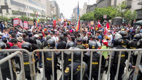 Gli agenti di polizia fanno la guardia mentre le persone si radunano fuori dal Congresso del Perù dopo che il presidente Pedro Castillo ha dichiarato che avrebbe sciolto l'assemblea il 7 dicembre.