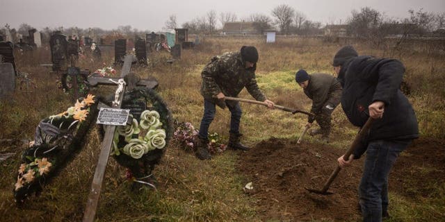 Residenti e funzionari ucraini riesumano il corpo di una ragazza di 16 anni e di altri sette uomini che sono stati uccisi dalle forze russe e sepolti nella città di Pravdin, alla periferia di Kherson, il 29 novembre 2022.