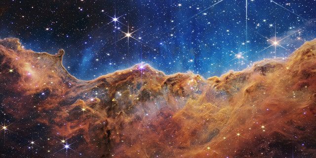 Ciò che assomiglia molto a montagne rocciose in una sera illuminata dalla luna è in realtà il bordo della vicina e giovane regione di formazione stellare NGC 3324 nella Nebulosa Carena.  Presa alla luce infrarossa dalla Near Infrared Camera (NIRCam) sul James Webb Space Telescope della NASA, questa immagine rivela regioni precedentemente oscurate della nascita delle stelle.